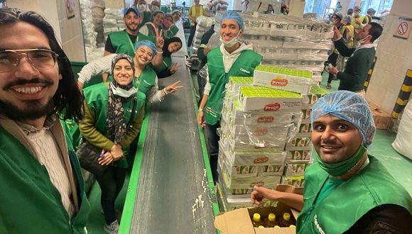 الموظفون بشركة كريم يشاركون في تجهيز كراتين السلع الغذائية التي يوفرها بنك الطعام المصري